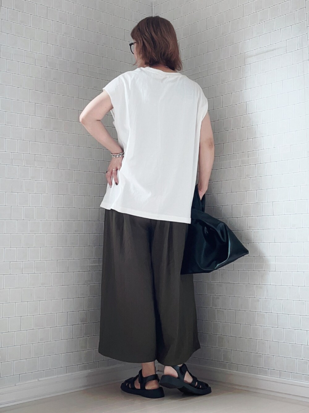 グリーン系のその他パンツ、ホワイト系のTシャツ/カットソー、ブラック系のサンダルを着用したレディースの夏コーディネートの4枚目の写真