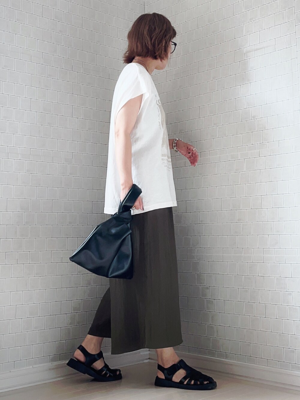 グリーン系のその他パンツ、ホワイト系のTシャツ/カットソー、ブラック系のサンダルを着用したレディースの夏コーディネートの3枚目の写真