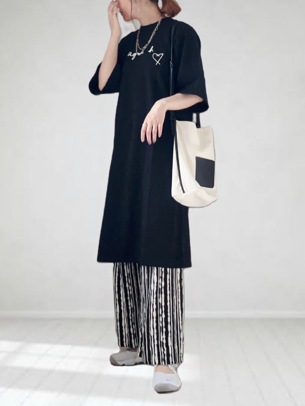 ブラック系のワンピース、ブラック系のその他パンツ、ホワイト系のショルダーバッグを着用したレディースの春コーディネートの3枚目の写真