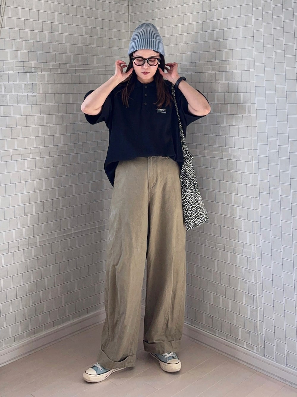 ベージュ系のその他パンツ、ブラック系のポロシャツ、ブラック系のトートバッグを着用したレディースの春コーディネートの2枚目の写真