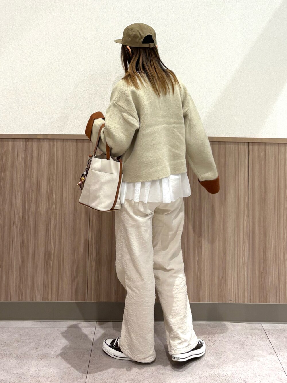 ホワイト系のカーディガン/ボレロ、ベージュ系のその他パンツ、ブラウン系のスニーカーを着用したレディースの秋コーディネートの5枚目の写真