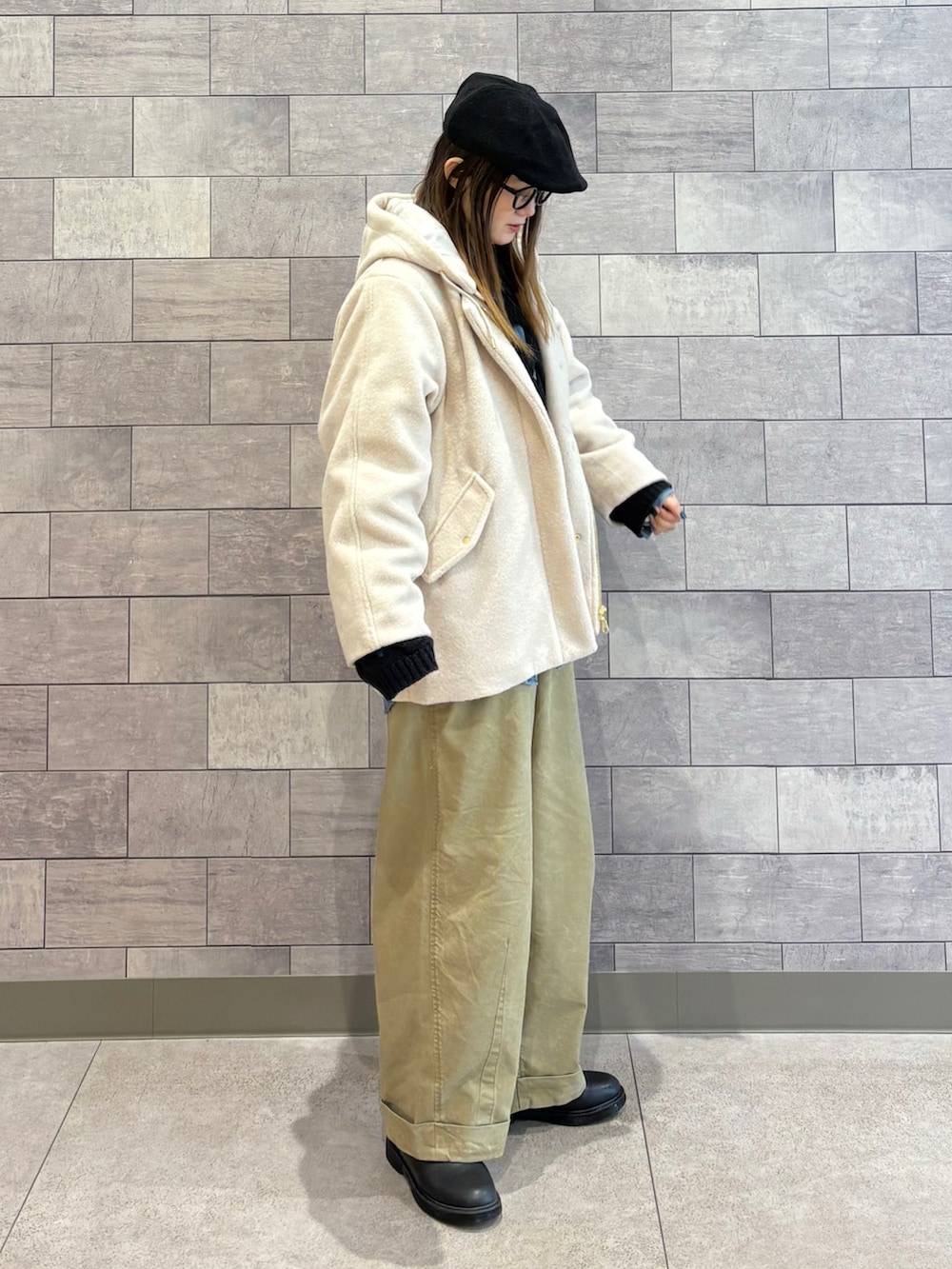 ブラック系のショルダーバッグ、ホワイト系のブルゾン、ブラック系のニット/セーターを着用したレディースの冬コーディネートの2枚目の写真