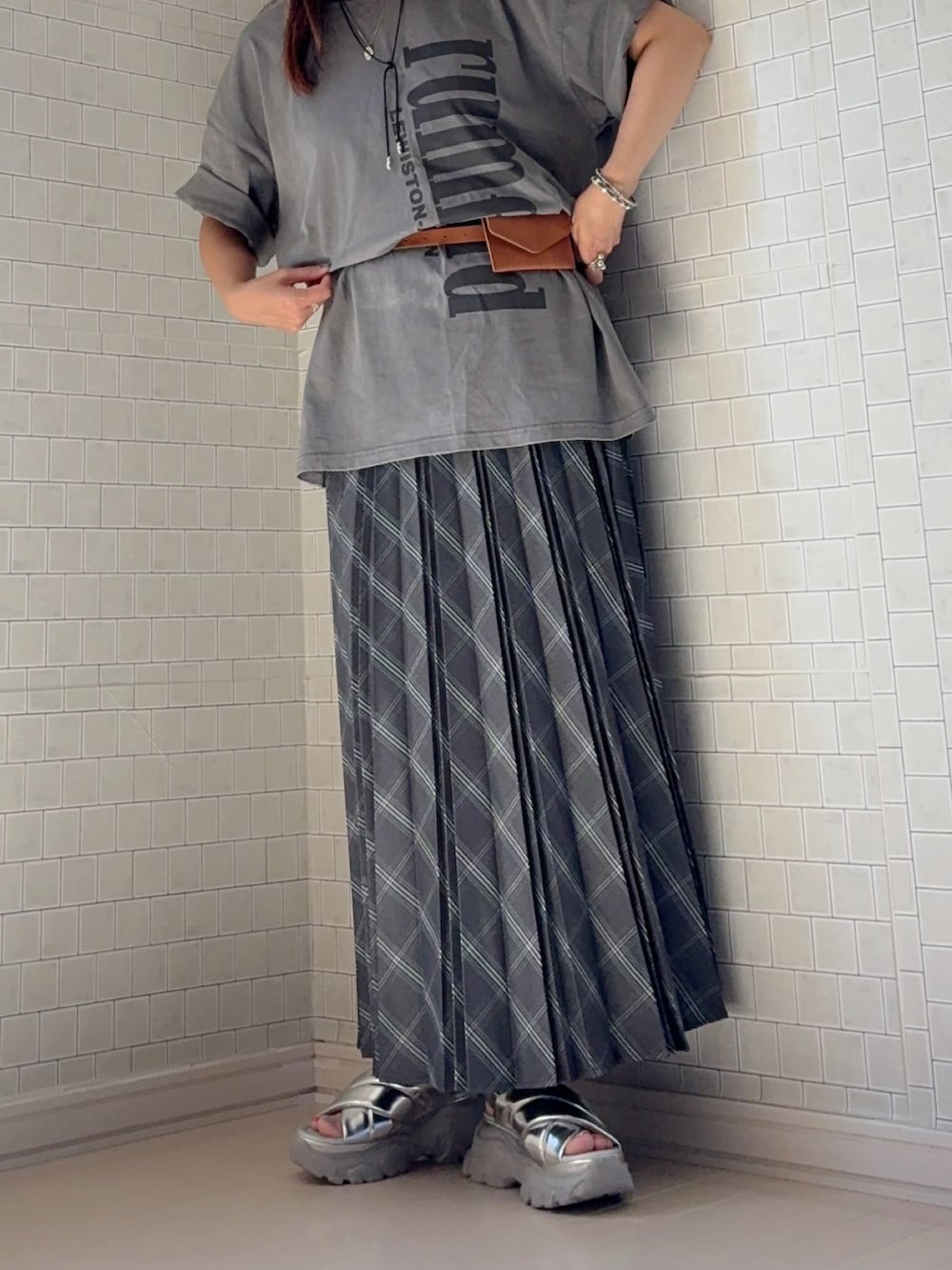 グレー系のスカート、グレー系のTシャツ/カットソー、シルバー系のサンダルを着用したレディースの夏コーディネートの3枚目の写真