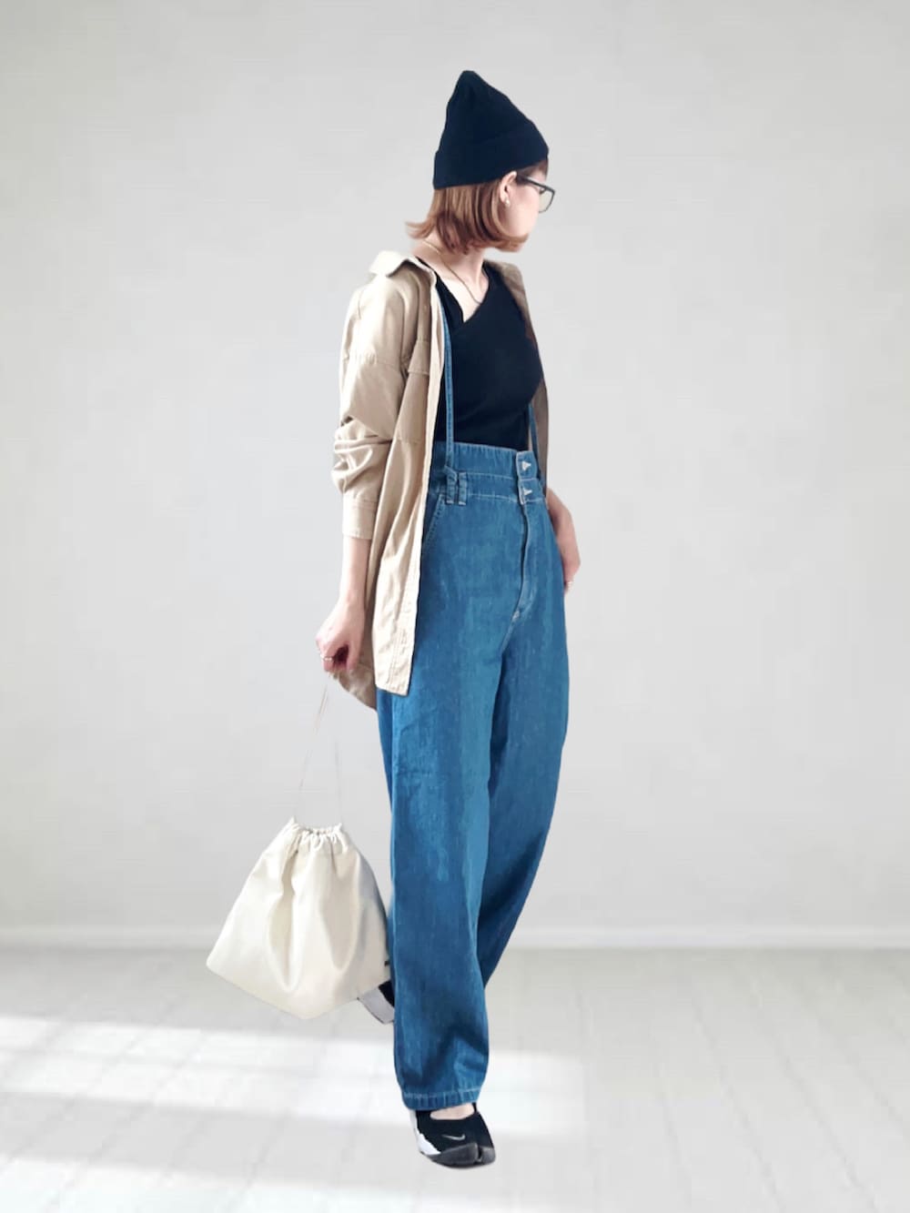 ブルー系のサロペット/オーバーオール、ベージュ系のシャツ/ブラウス、ブラック系のタンクトップを着用したレディースの春コーディネートの2枚目の写真