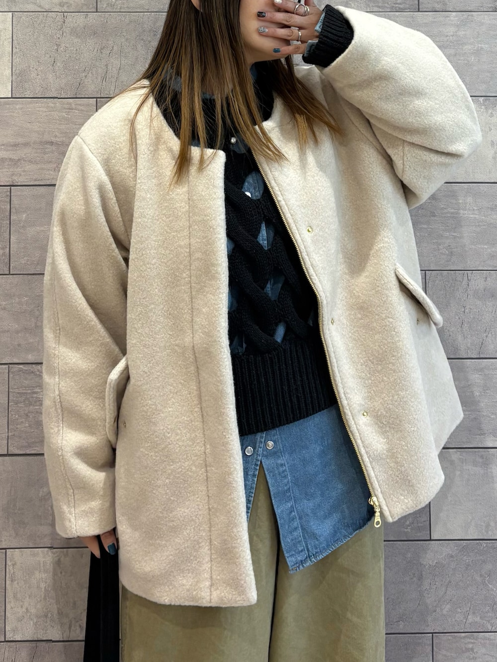 ブラック系のショルダーバッグ、ホワイト系のブルゾン、ブラック系のニット/セーターを着用したレディースの冬コーディネートの5枚目の写真