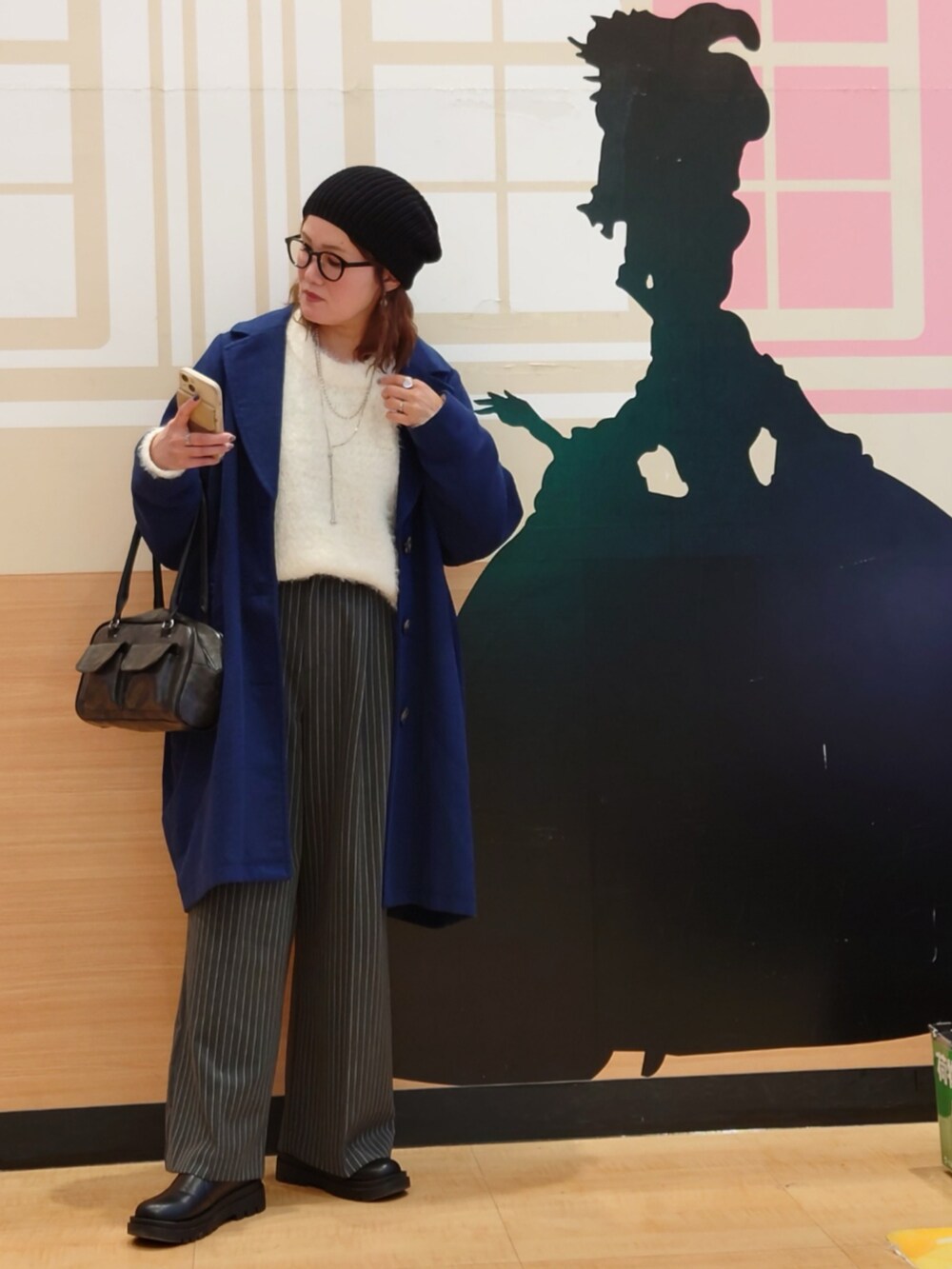 ホワイト系のニット/セーター、ブルー系のチェスターコート、グレー系のその他パンツを着用したレディースの冬コーディネートの4枚目の写真