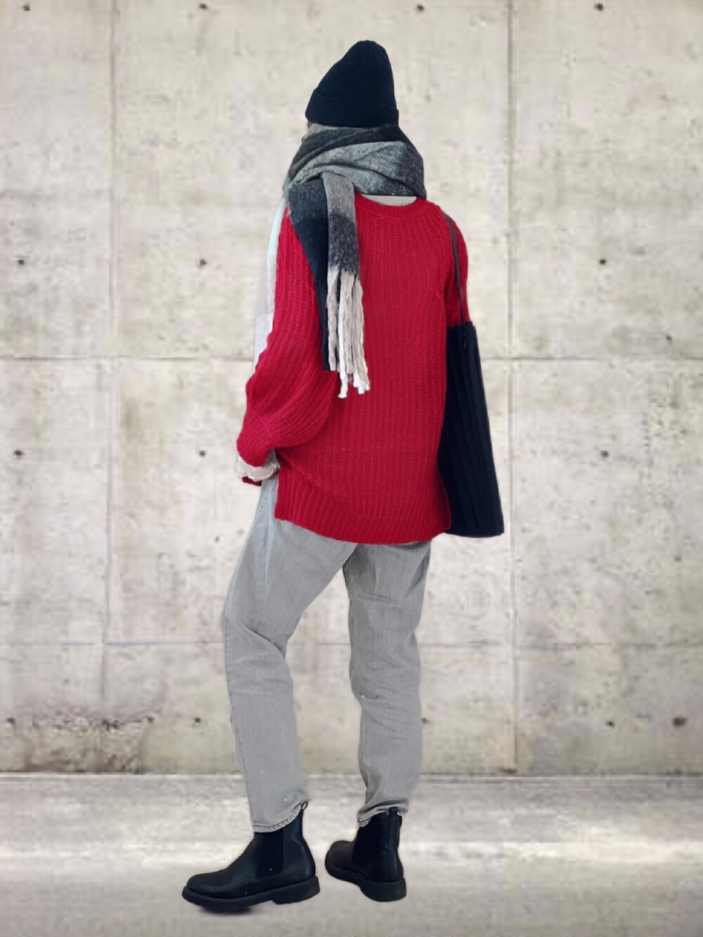 レッド系のニット/セーター、ベージュ系のデニムパンツ、ブラック系のトートバッグを着用したレディースの冬コーディネートの3枚目の写真