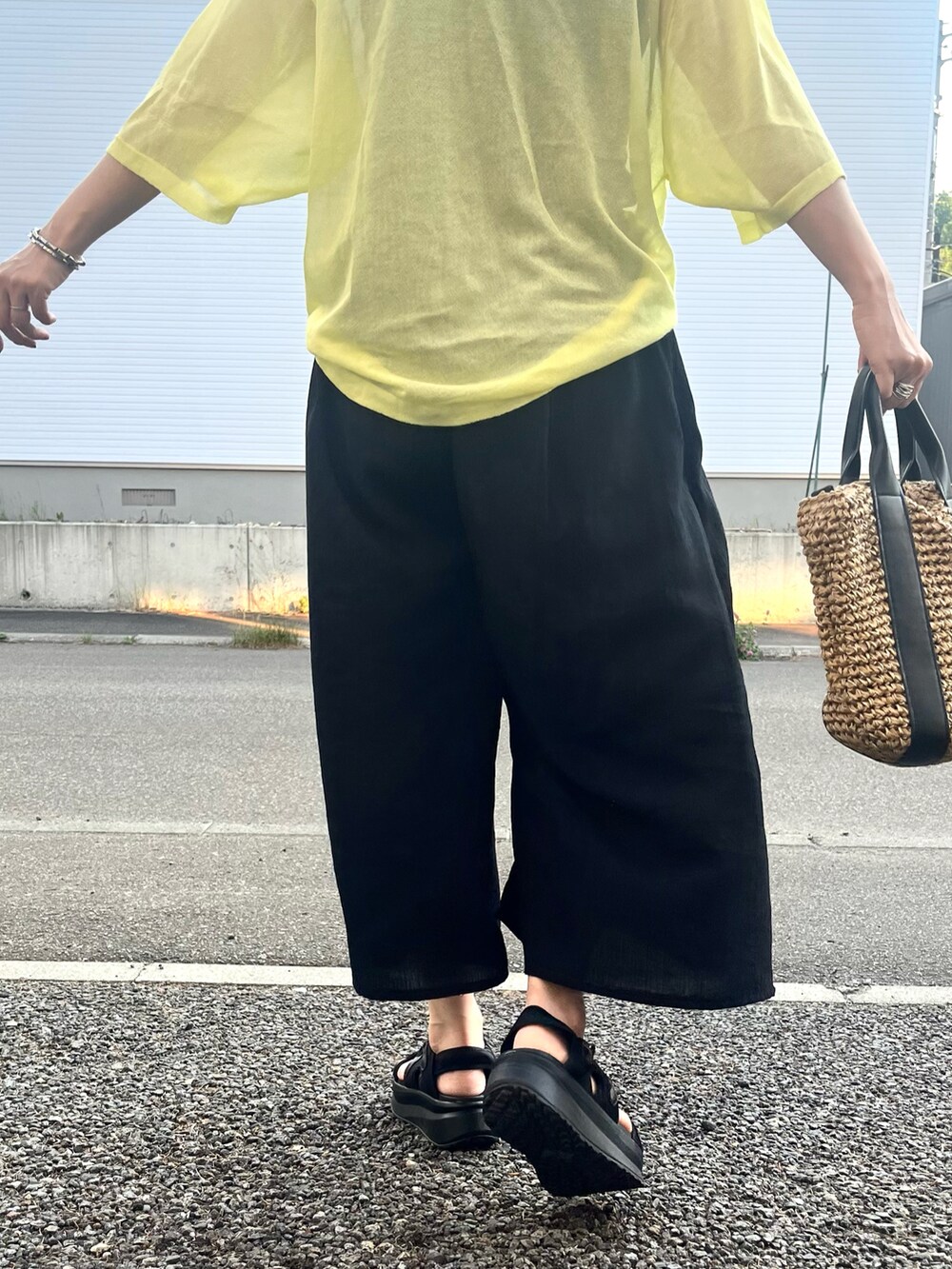 ブラック系のその他パンツ、ブラック系のショルダーバッグ、イエロー系のTシャツ/カットソーを着用したレディースの夏コーディネートの4枚目の写真