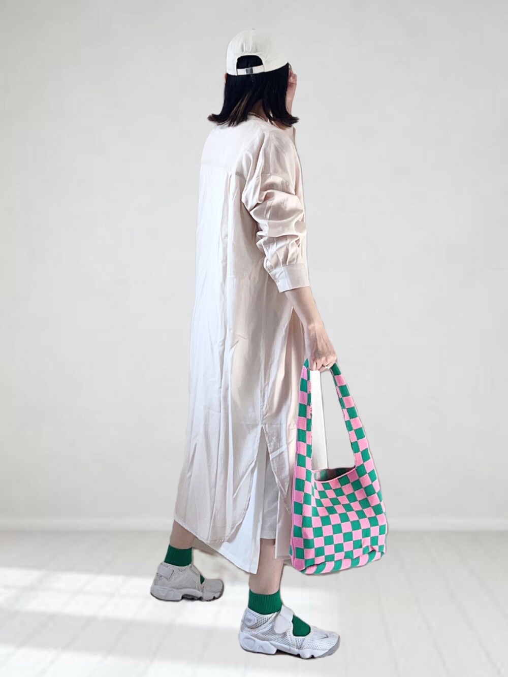 ベージュ系のシャツワンピース、ホワイト系のワンピース、ホワイト系のスニーカーを着用したレディースの夏コーディネートの2枚目の写真