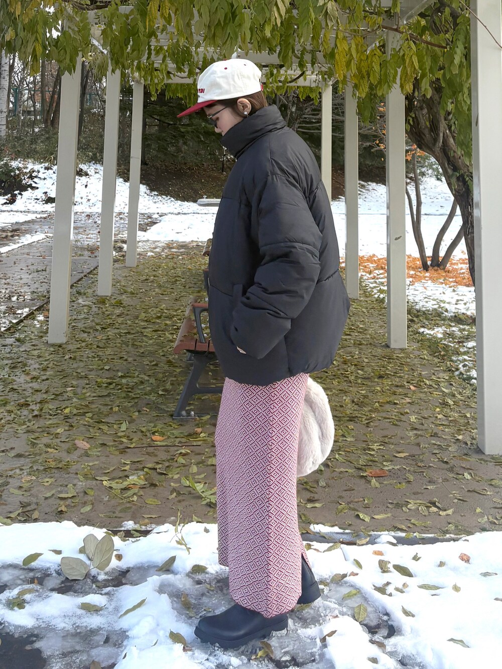 ブラック系のダウンジャケット/コート、ベージュ系のショルダーバッグ、ブラック系のブーツを着用したレディースの冬コーディネートの3枚目の写真