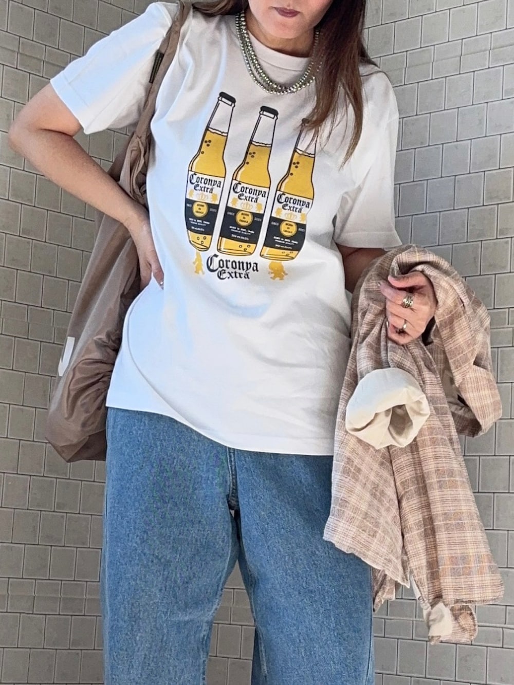 ホワイト系のTシャツ/カットソー、ベージュ系のテーラードジャケット、ブラウン系のスニーカーを着用したレディースの春コーディネートの3枚目の写真