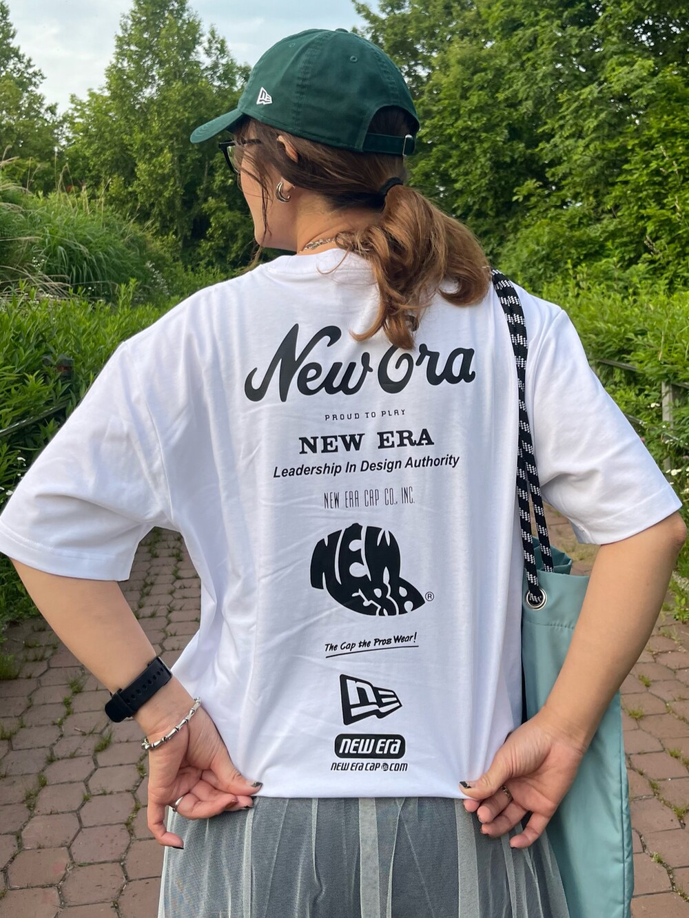 ホワイト系のTシャツ/カットソー、ブルー系のデニムパンツ、ホワイト系のスカートを着用したレディースの夏コーディネートの4枚目の写真