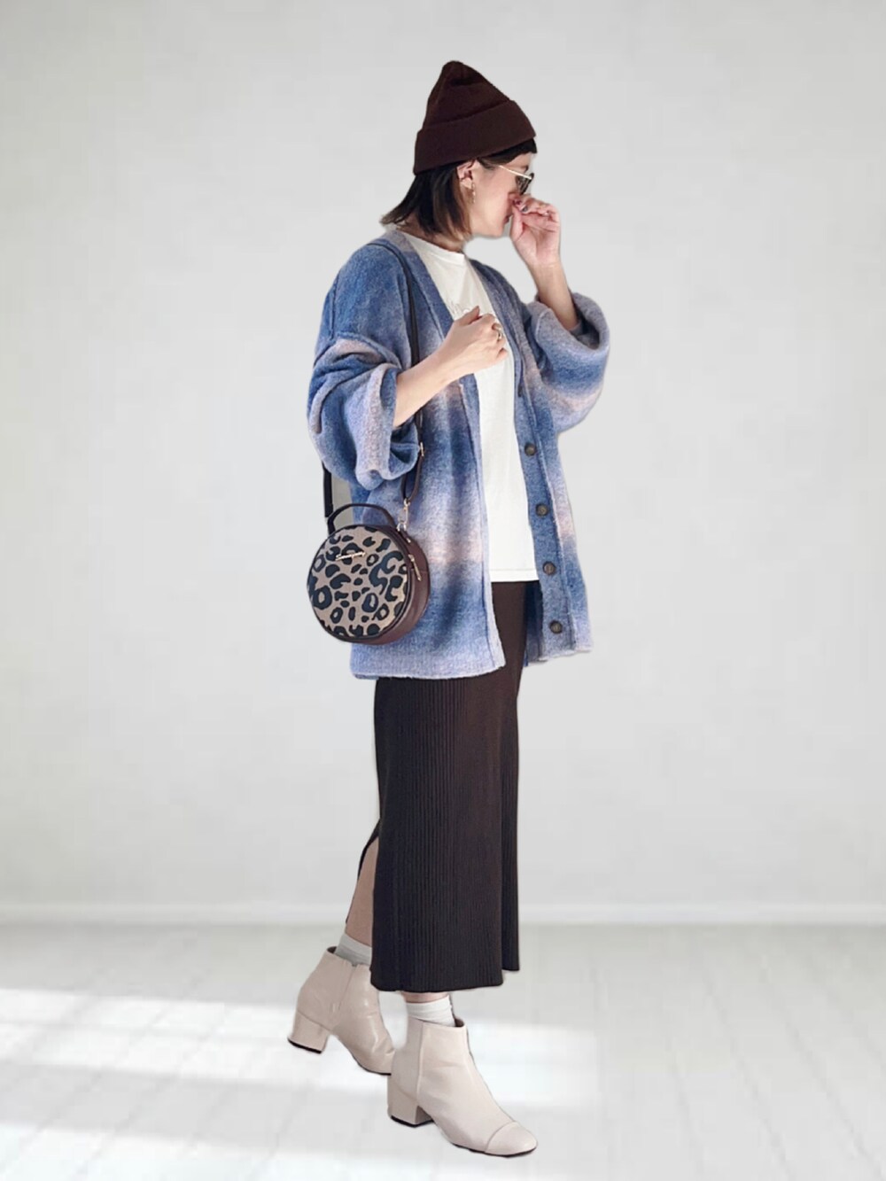ブルー系のカーディガン/ボレロ、ホワイト系のTシャツ/カットソー、ブラウン系のショルダーバッグを着用したレディースの秋コーディネートの2枚目の写真