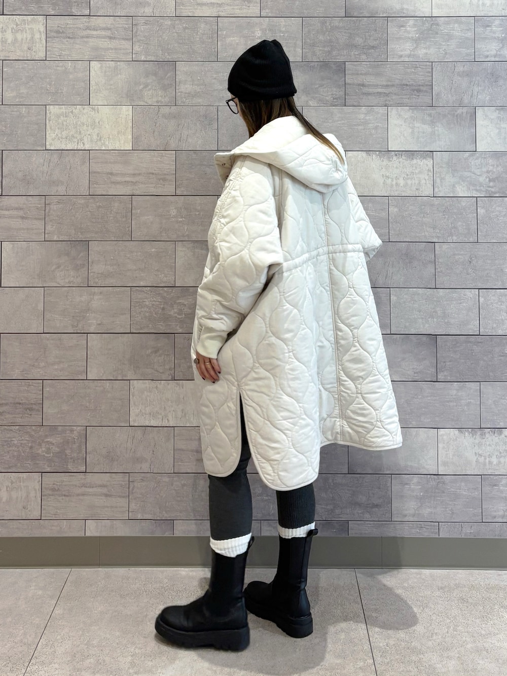 ホワイト系のダウンジャケット/コート、ブラック系のショルダーバッグ、ブラック系のブーツを着用したレディースの秋コーディネートの3枚目の写真