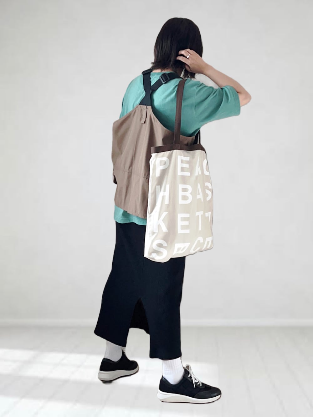 ブラック系のスニーカー、グリーン系のTシャツ/カットソー、ブラウン系のベストを着用したレディースの夏コーディネートの3枚目の写真