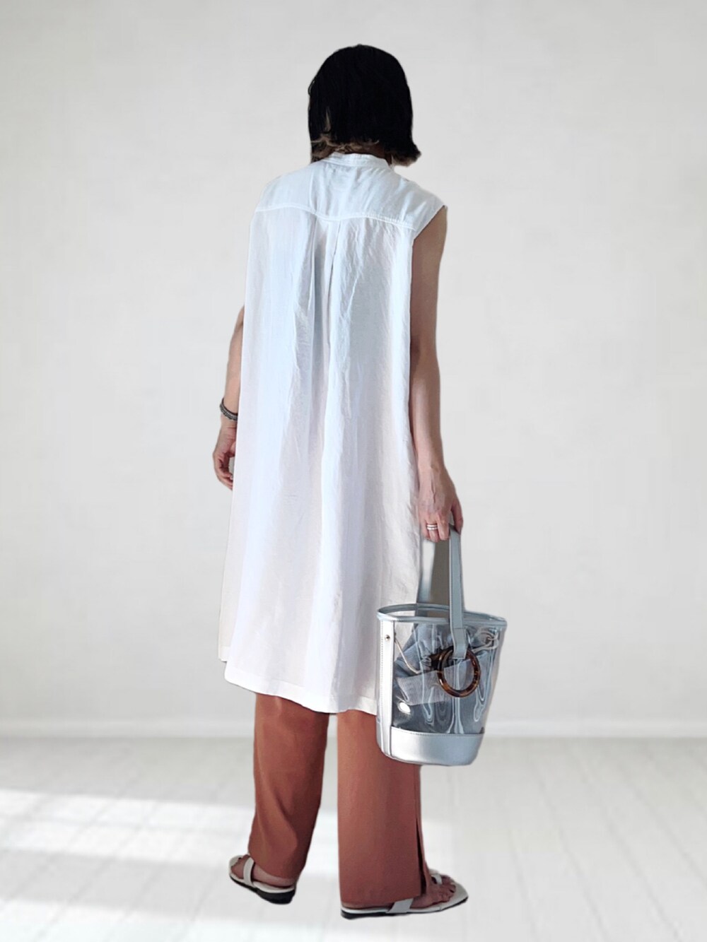 ホワイト系のシャツ/ブラウス、オレンジ系のその他パンツ、シルバー系のショルダーバッグを着用したレディースの夏コーディネートの2枚目の写真