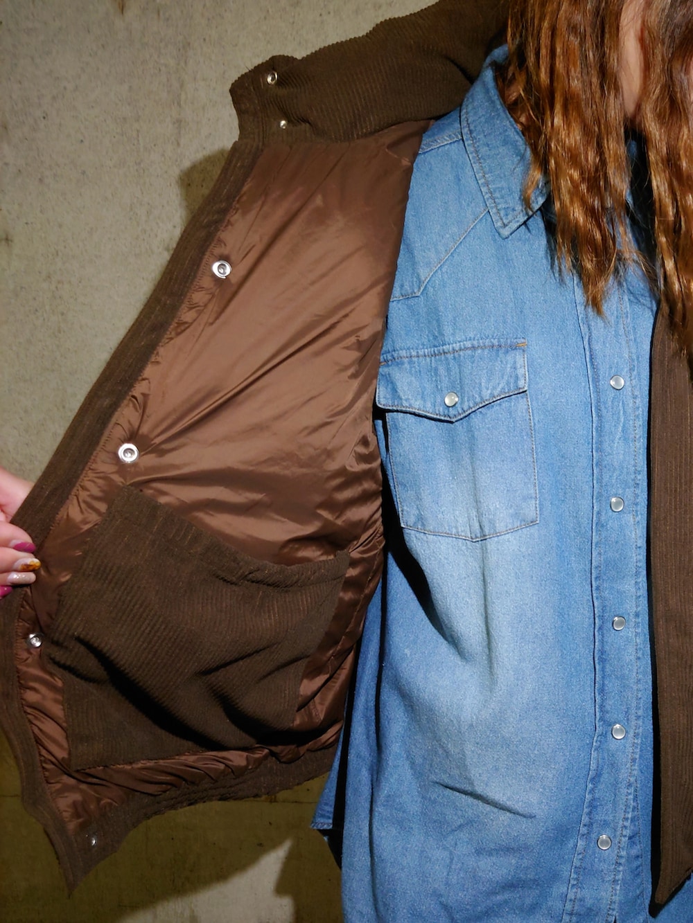 ブラウン系のダウンベスト、ブルー系のシャツ/ブラウス、ブラウン系のスニーカーを着用したレディースの秋コーディネートの5枚目の写真