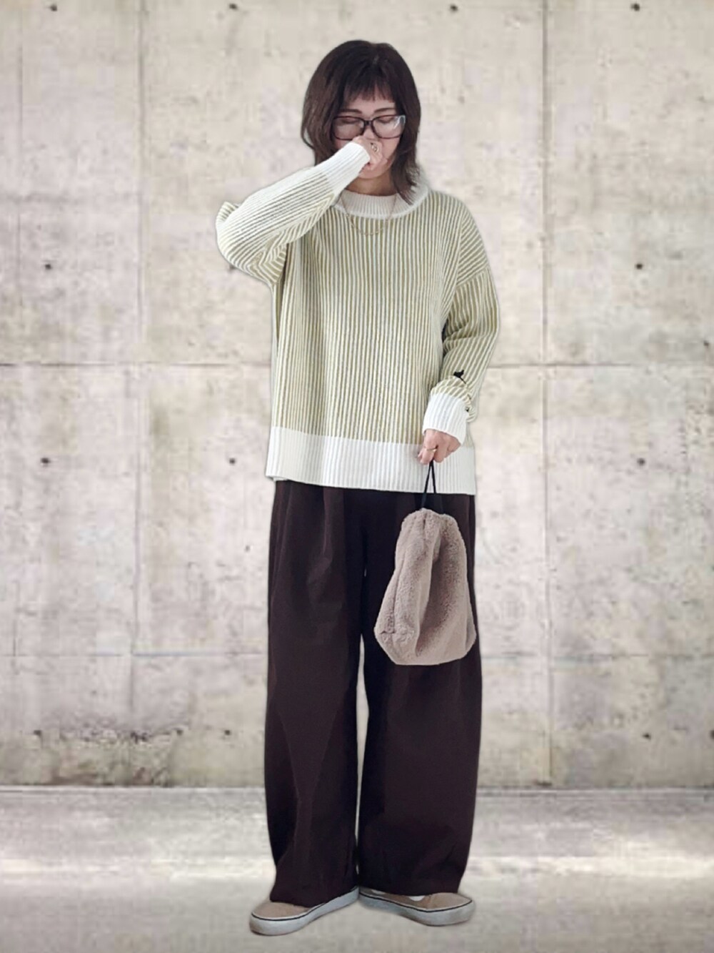 グリーン系のニット/セーター、ブラウン系のその他パンツ、ブラック系のショルダーバッグを着用したレディースの冬コーディネートの2枚目の写真