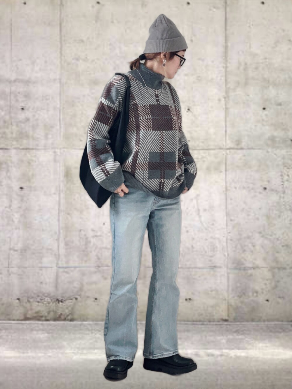 グレー系のニット/セーター、ブルー系のデニムパンツ、ブラック系のトートバッグを着用したレディースの冬コーディネートの4枚目の写真