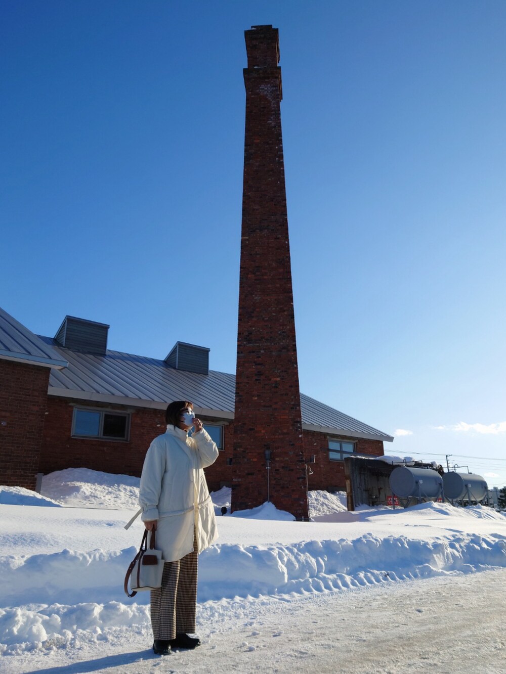 ホワイト系のその他アウター、ブラック系のニット/セーター、ベージュ系のサロペット/オーバーオールを着用したレディースの冬コーディネートの5枚目の写真