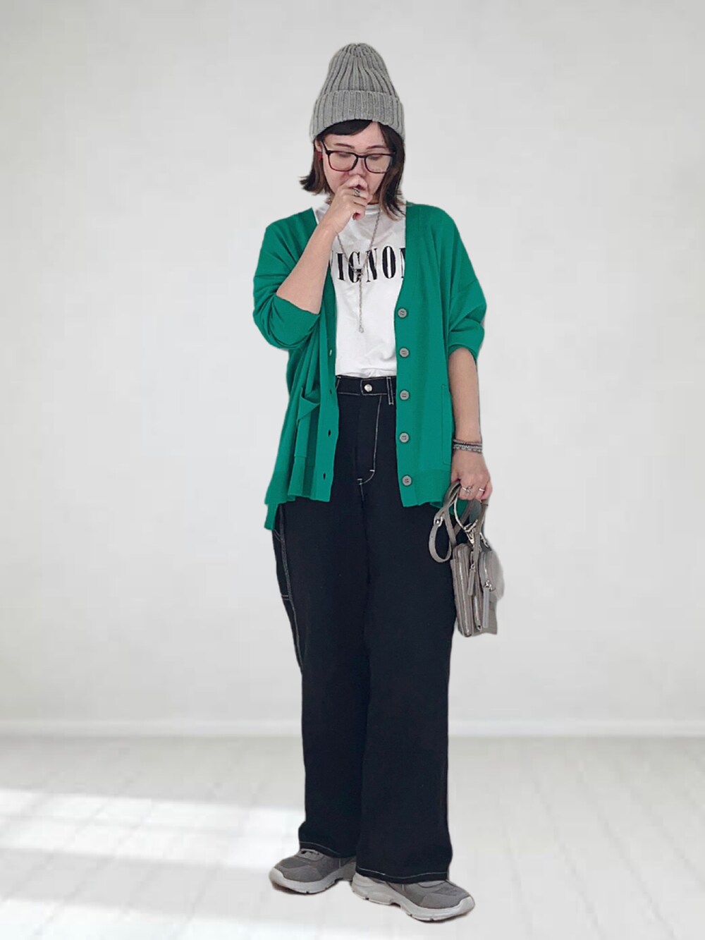 ブラック系のデニムパンツ、グリーン系のカーディガン/ボレロ、ホワイト系のTシャツ/カットソーを着用したレディースの秋コーディネートの3枚目の写真