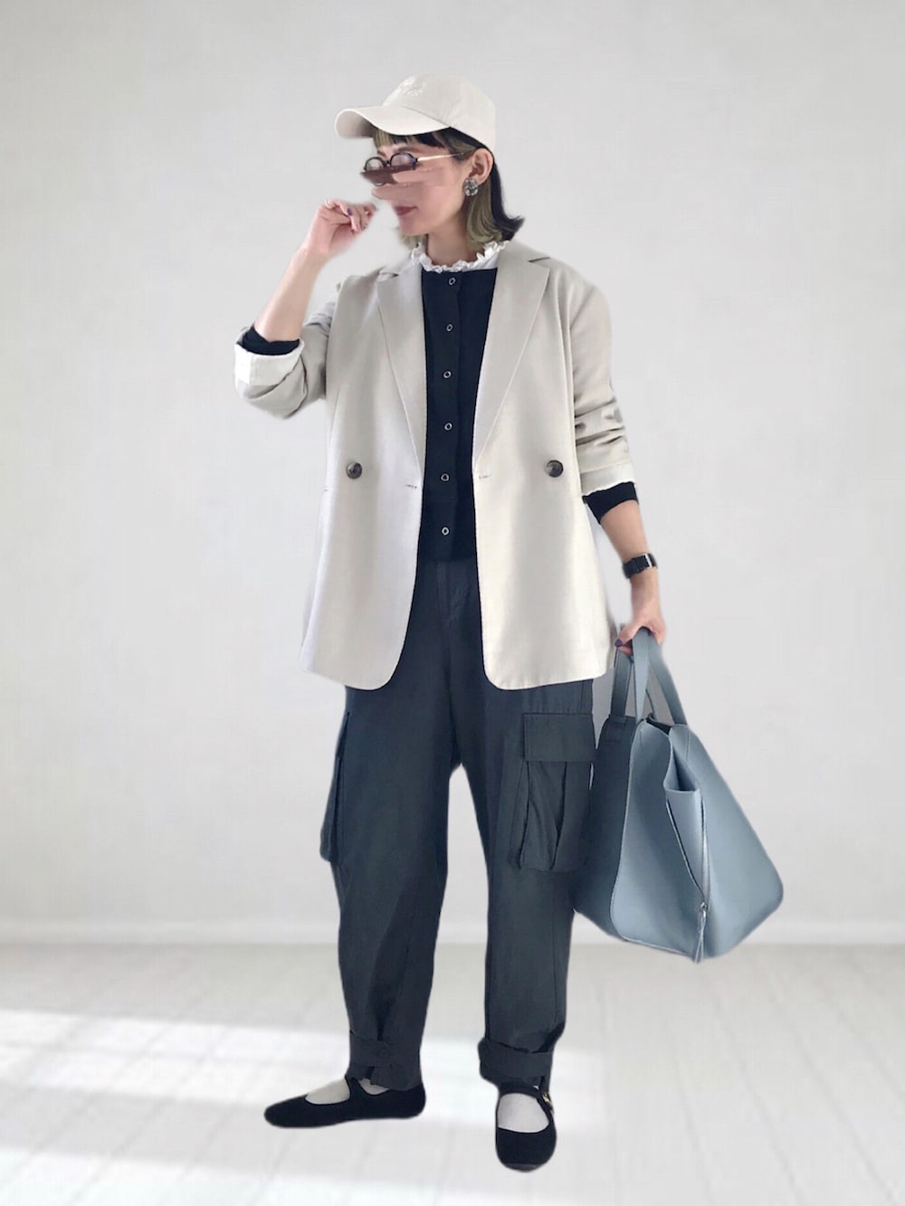 ベージュ系のテーラードジャケット、ブラック系のスウェット、グレー系のカーゴパンツを着用したレディースの春コーディネートの2枚目の写真