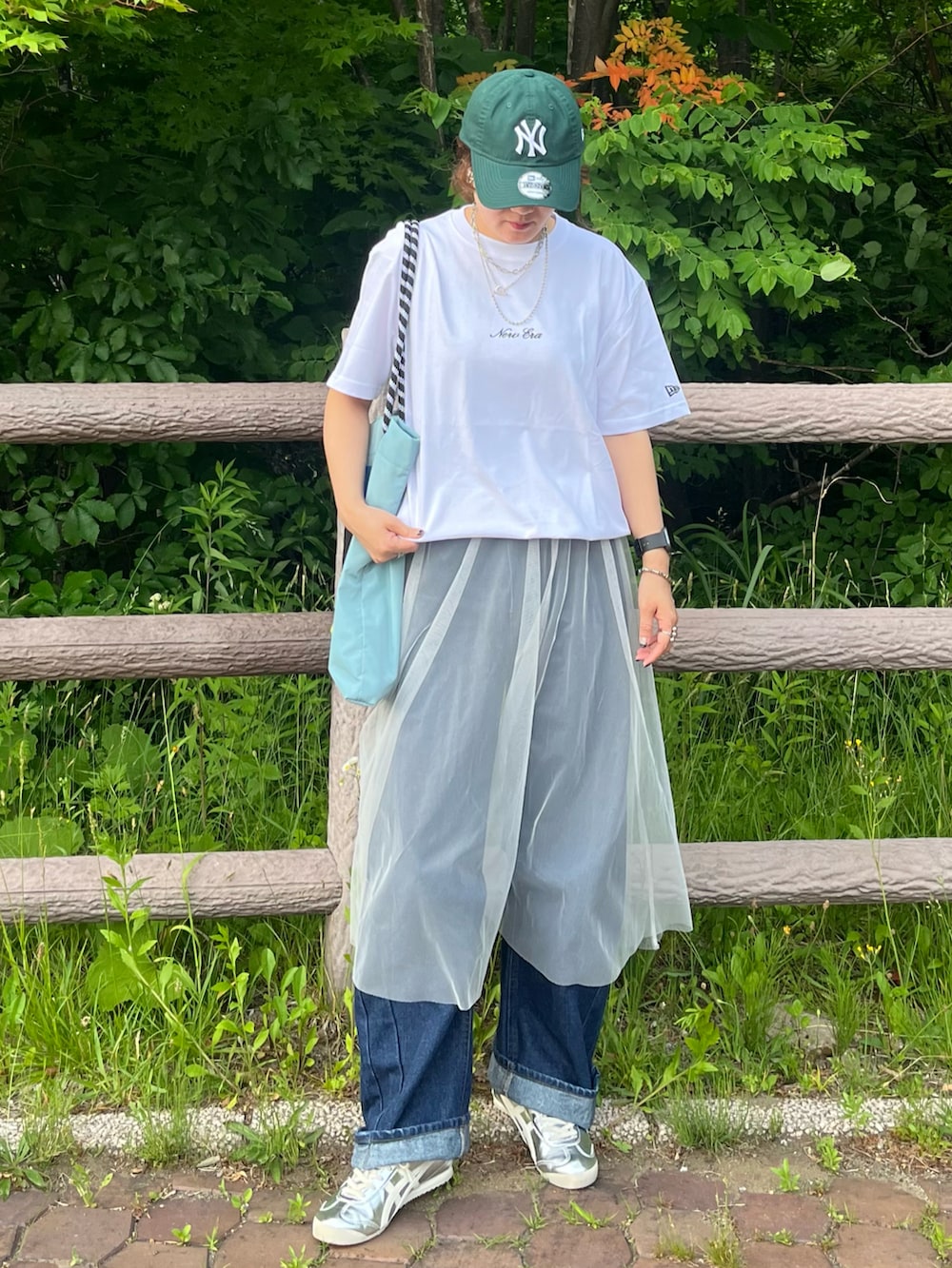 ホワイト系のTシャツ/カットソー、ブルー系のデニムパンツ、ホワイト系のスカートを着用したレディースの夏コーディネートの2枚目の写真