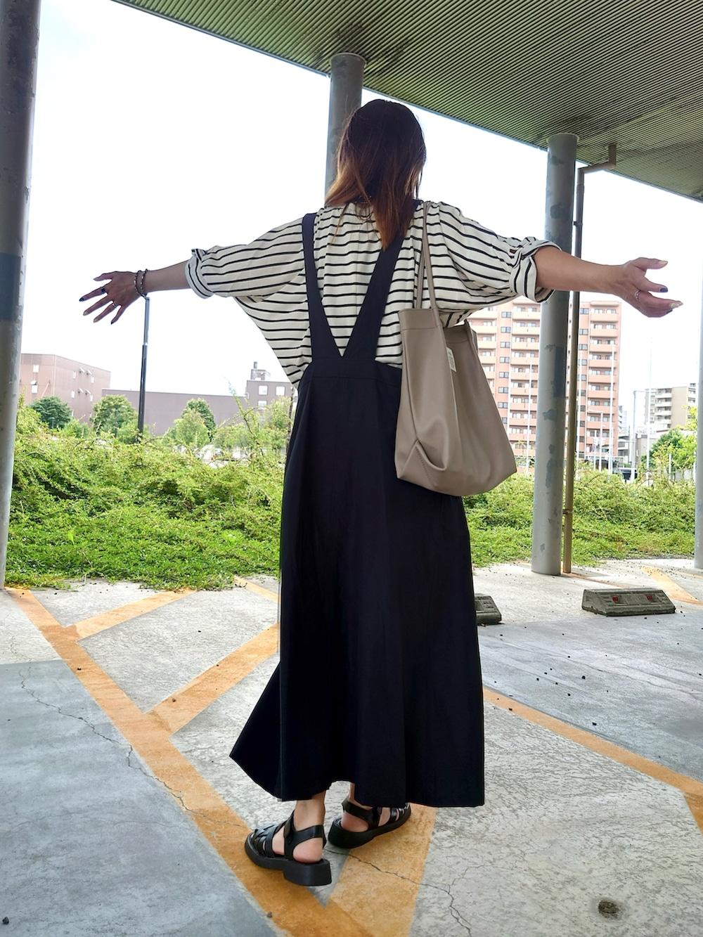 ブラック系のサンダル、その他のTシャツ/カットソー、ベージュ系のトートバッグを着用したレディースの夏コーディネートの2枚目の写真