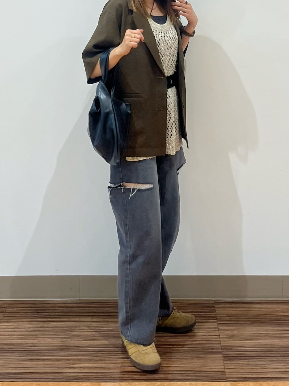ブラック系のデニムパンツ、ブラウン系のテーラードジャケット、ゴールド系のベストを着用したレディースの夏コーディネートの2枚目の写真