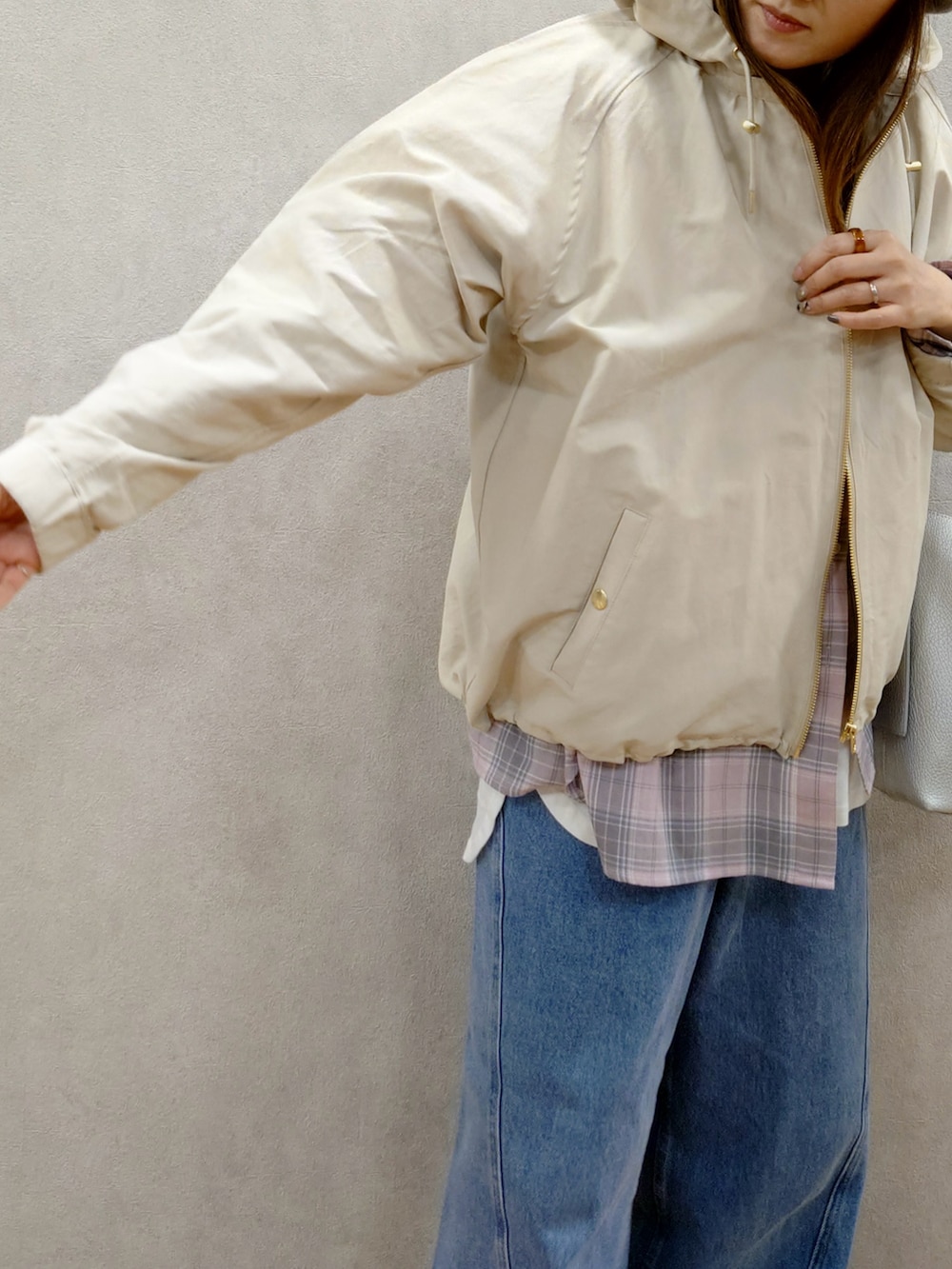 ホワイト系のマウンテンパーカー、ピンク系のシャツ/ブラウス、ブラウン系のスニーカーを着用したレディースの春コーディネートの4枚目の写真