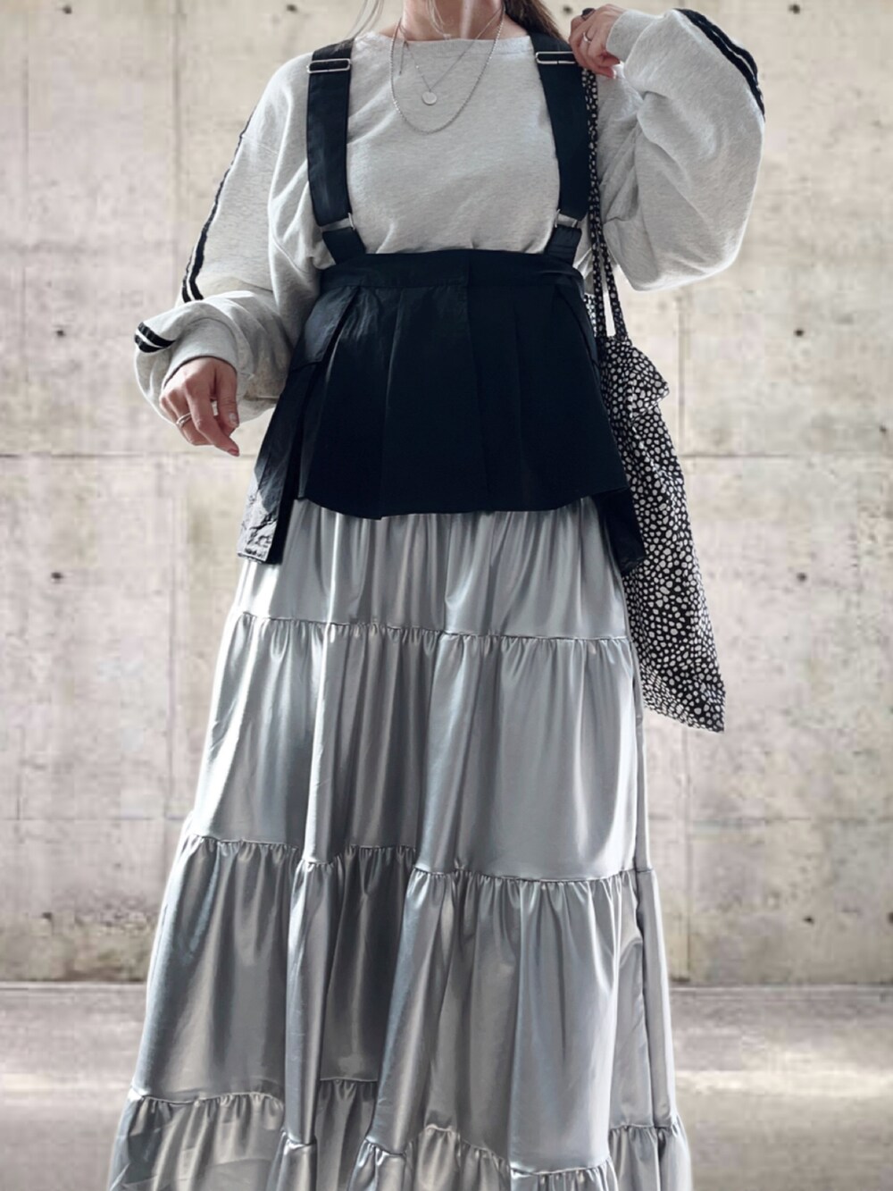 グレー系のTシャツ/カットソー、ブラック系のベスト、ブラック系のスニーカーを着用したレディースの春コーディネートの5枚目の写真