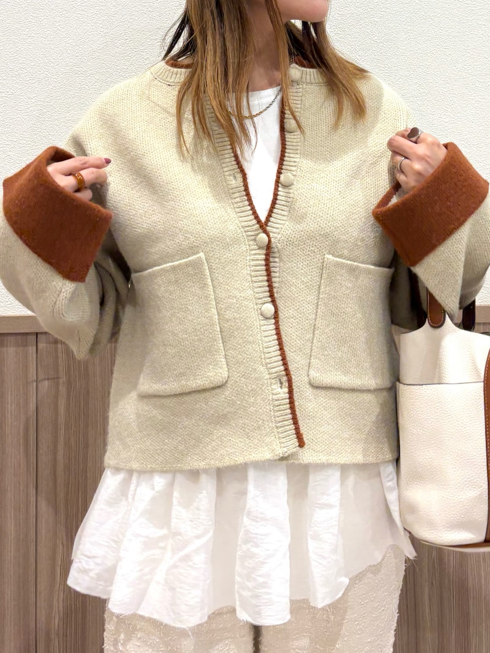 ホワイト系のカーディガン/ボレロ、ベージュ系のその他パンツ、ブラウン系のスニーカーを着用したレディースの秋コーディネートの4枚目の写真
