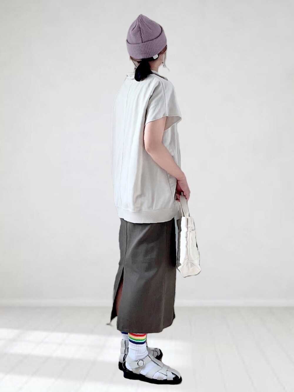 ベージュ系のTシャツ/カットソー、グレー系のスカート、ホワイト系のトートバッグを着用したレディースの春コーディネートの3枚目の写真