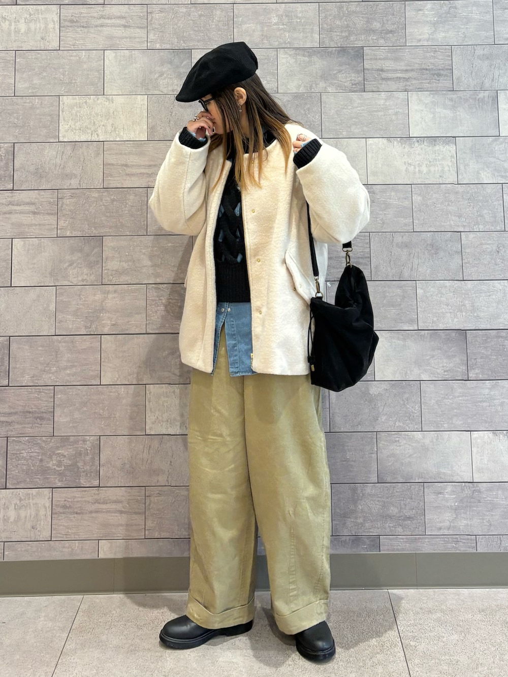 ブラック系のショルダーバッグ、ホワイト系のブルゾン、ブラック系のニット/セーターを着用したレディースの冬コーディネートの4枚目の写真