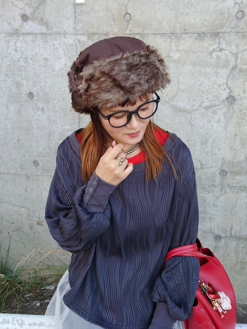 グレー系のデニムパンツ、ブラック系のスニーカー、ホワイト系のスカートを着用したレディースの秋コーディネートの2枚目の写真