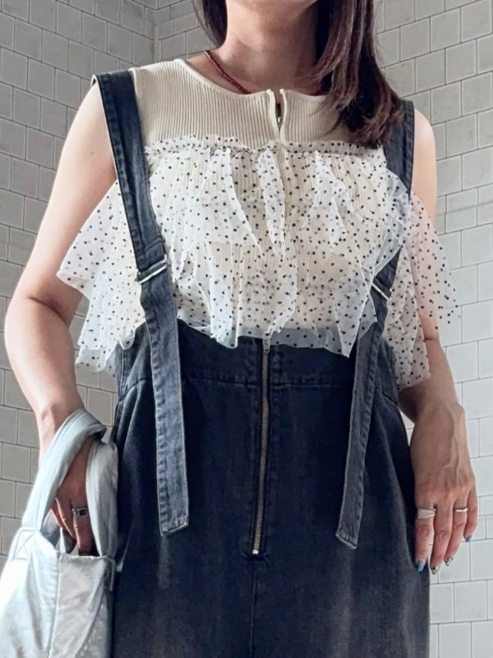 ホワイト系のニット/セーター、グレー系のデニムパンツ、ブラック系のサンダルを着用したレディースの夏コーディネートの3枚目の写真