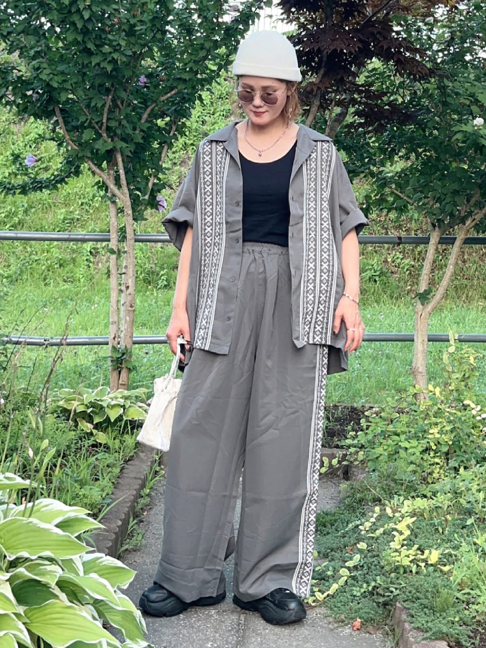 グレー系のシャツ/ブラウス、グレー系のその他パンツ、ブラック系のスニーカーを着用したレディースの夏コーディネートの3枚目の写真