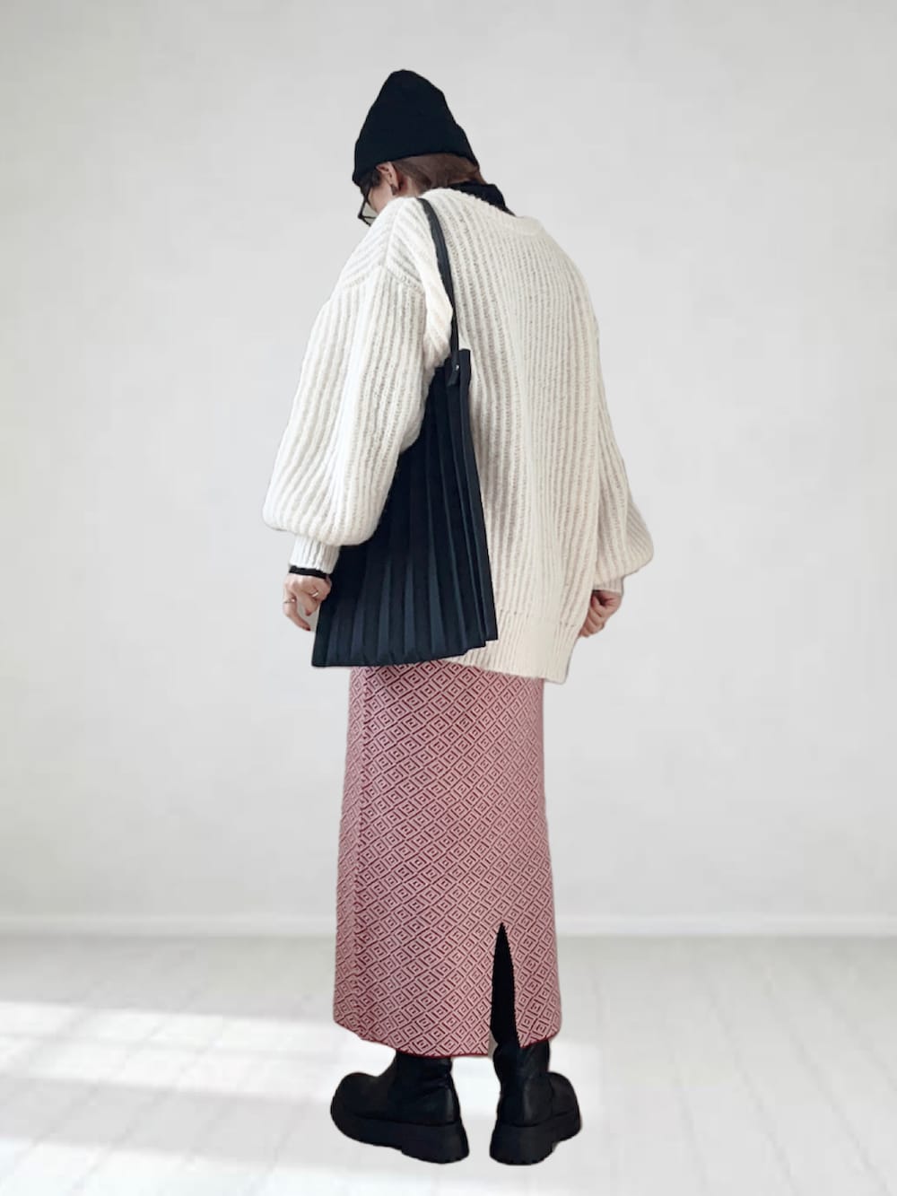 ホワイト系のカーディガン/ボレロ、ブラック系のTシャツ/カットソー、レッド系のスカートを着用したレディースの冬コーディネートの2枚目の写真