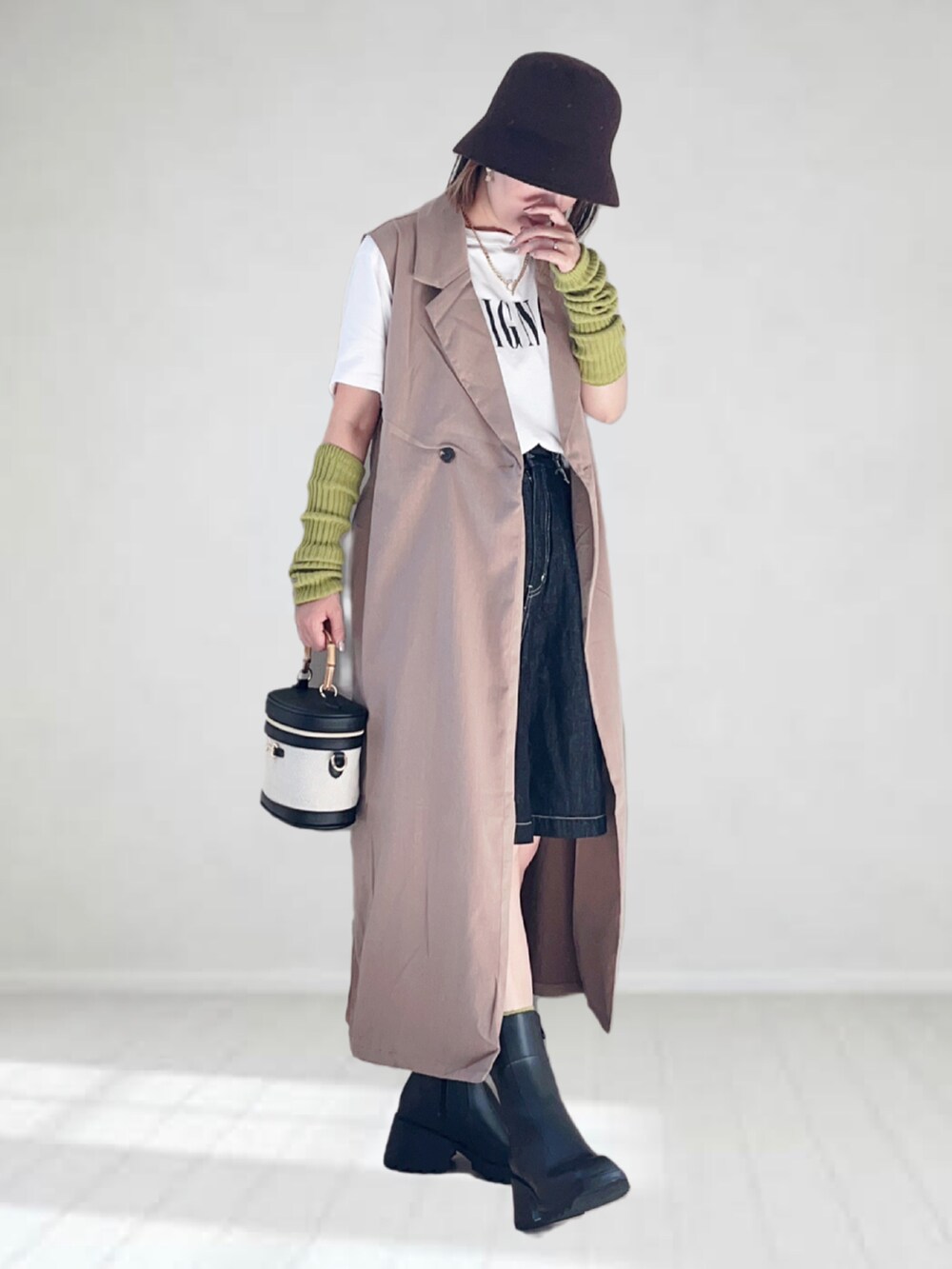 ベージュ系のベスト、ホワイト系のTシャツ/カットソー、ブラック系のデニムパンツを着用したレディースの秋コーディネートの2枚目の写真