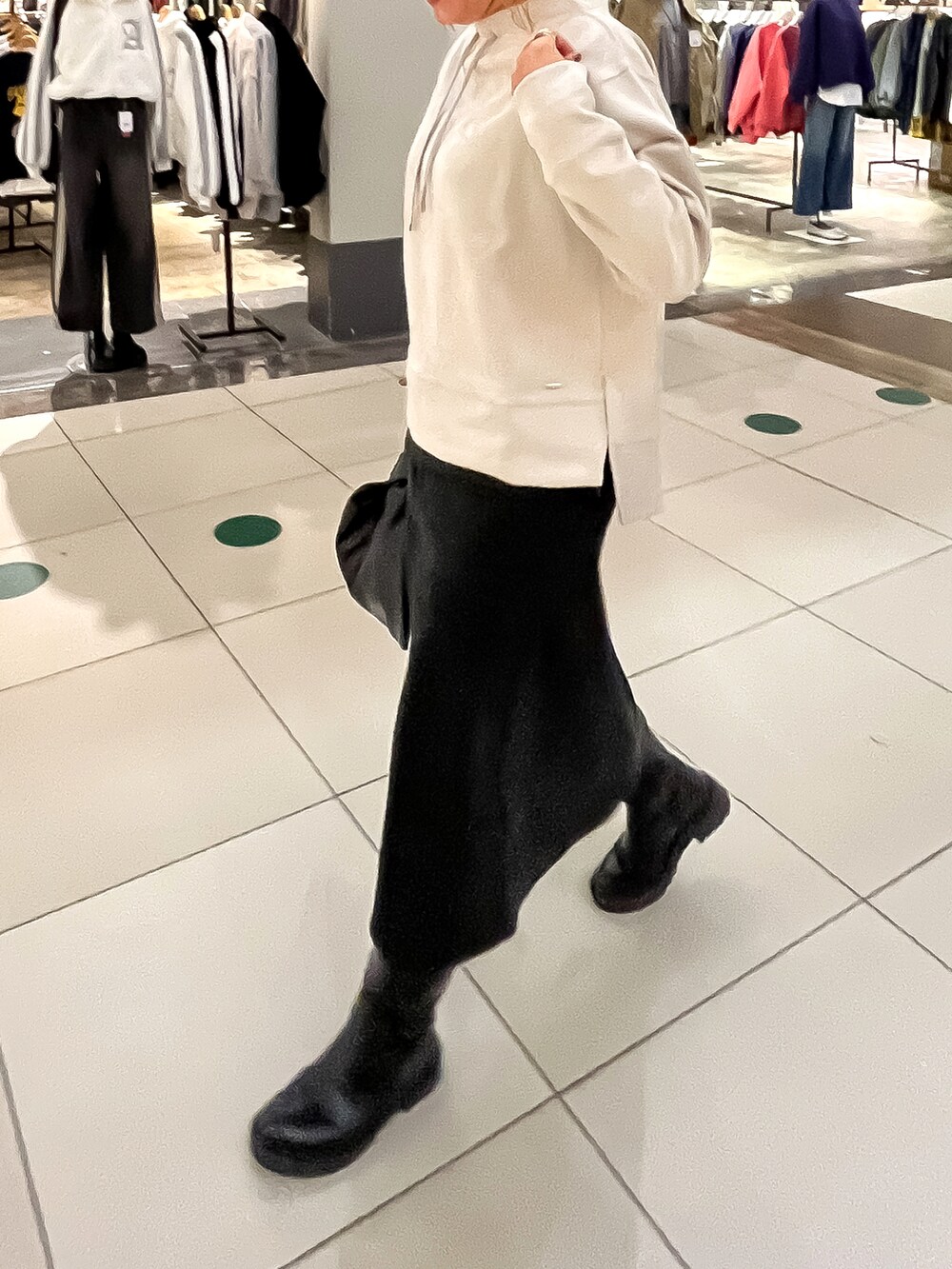 ベージュ系のスウェット、ブラック系のスカート、ブラック系のチェスターコートを着用したレディースの秋コーディネートの3枚目の写真