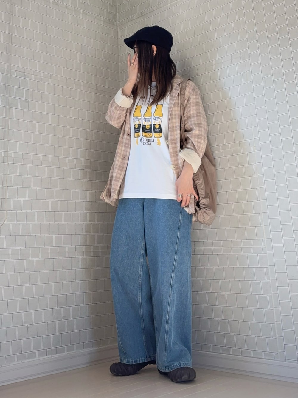 ホワイト系のTシャツ/カットソー、ベージュ系のテーラードジャケット、ブラウン系のスニーカーを着用したレディースの春コーディネートの2枚目の写真