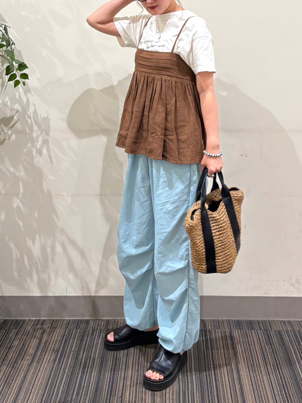 ブルー系のその他パンツ、ブラック系のショルダーバッグ、ブラウン系のキャミソールを着用したレディースの夏コーディネートの4枚目の写真