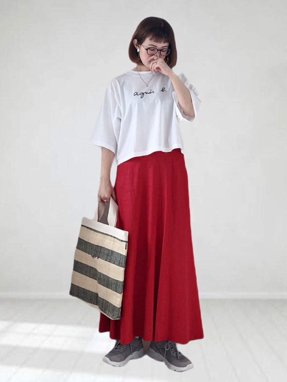 ホワイト系のTシャツ/カットソー、ブラック系のトートバッグ、レッド系のスカートを着用したレディースの春コーディネートの2枚目の写真