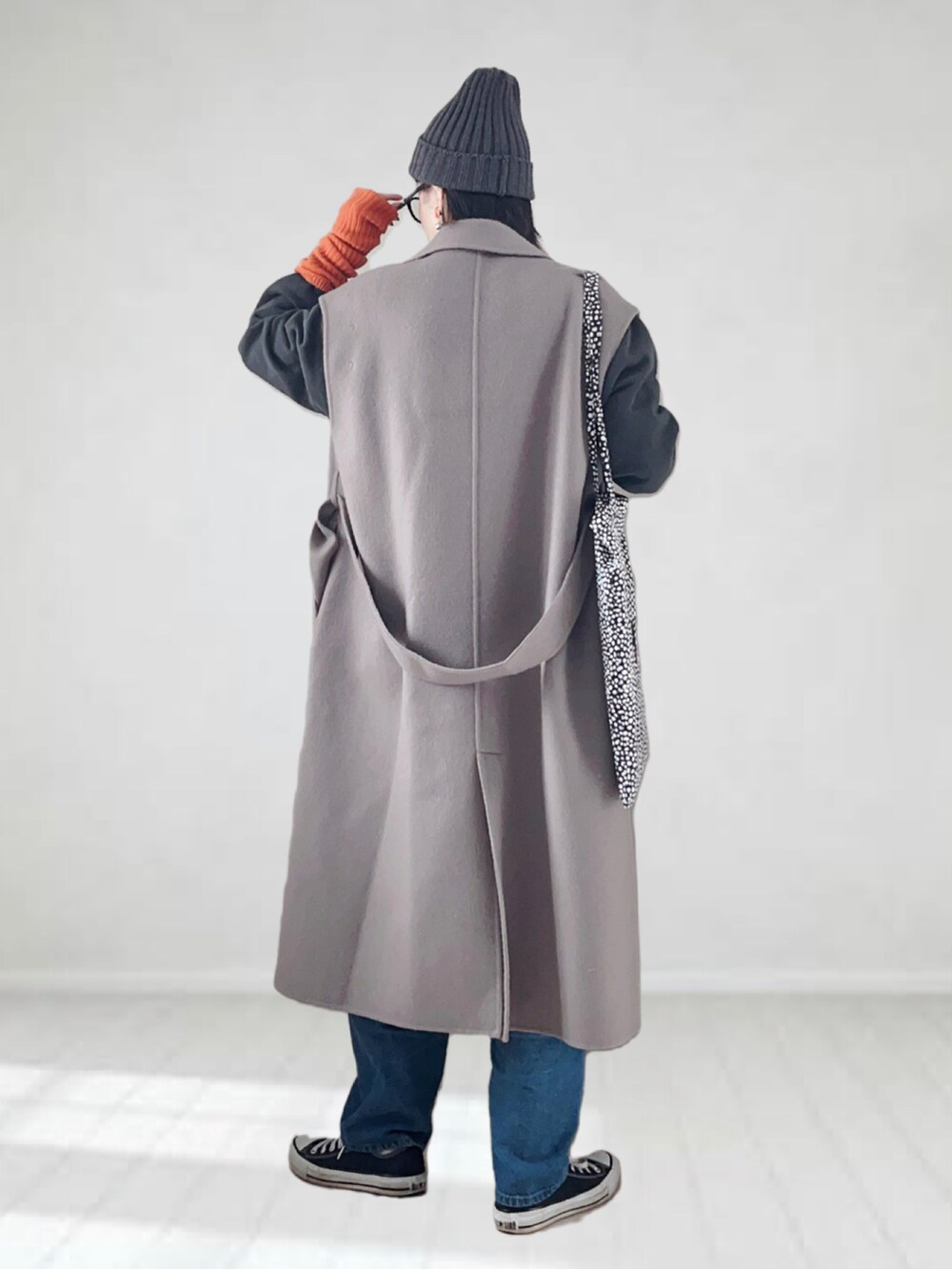 ブラウン系のチェスターコート、オレンジ系のTシャツ/カットソー、グレー系のスウェットを着用したレディースの冬コーディネートの4枚目の写真