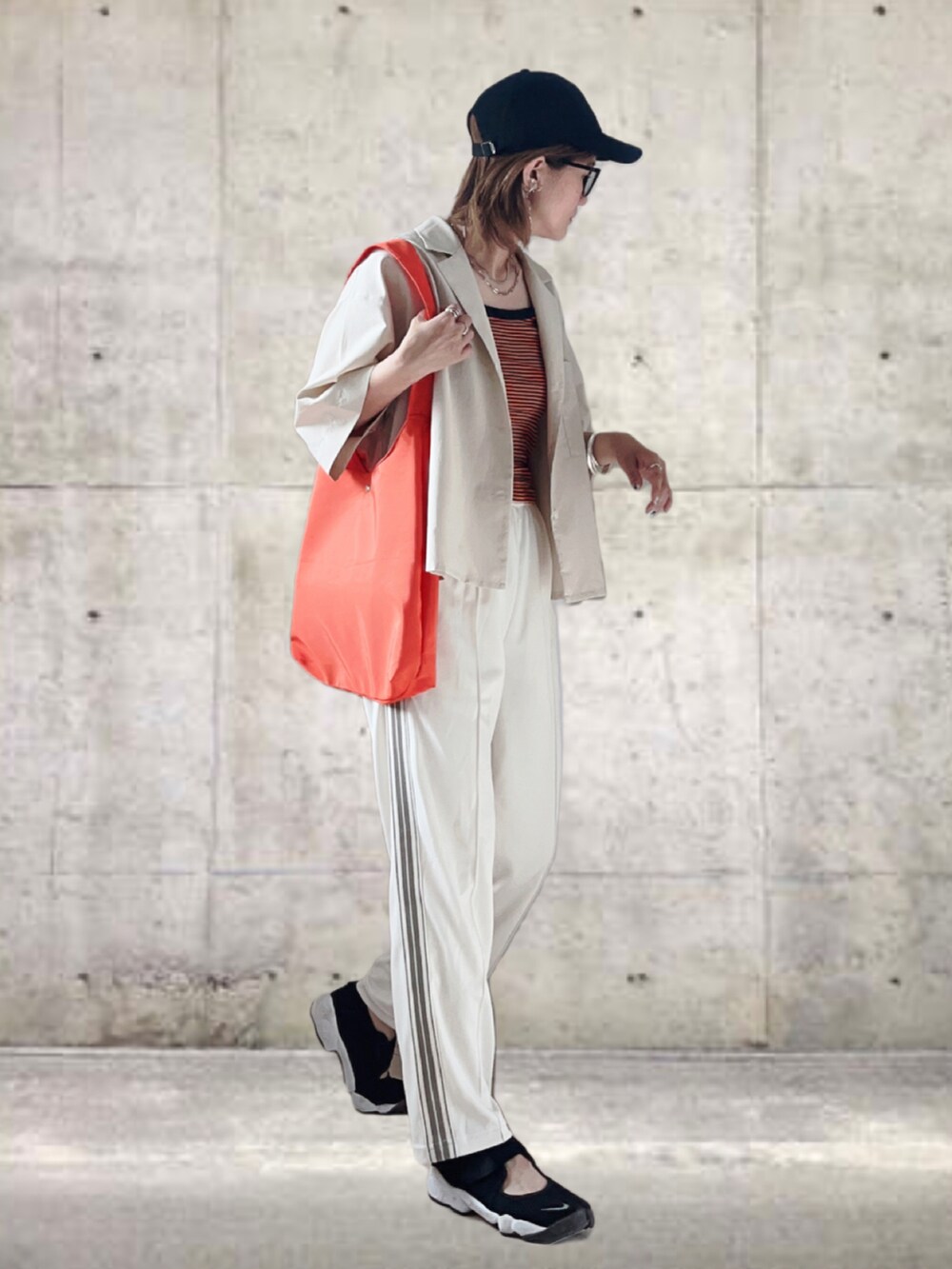 ホワイト系のシャツ/ブラウス、ホワイト系のパンツ、オレンジ系のトートバッグを着用したレディースの夏コーディネートの3枚目の写真