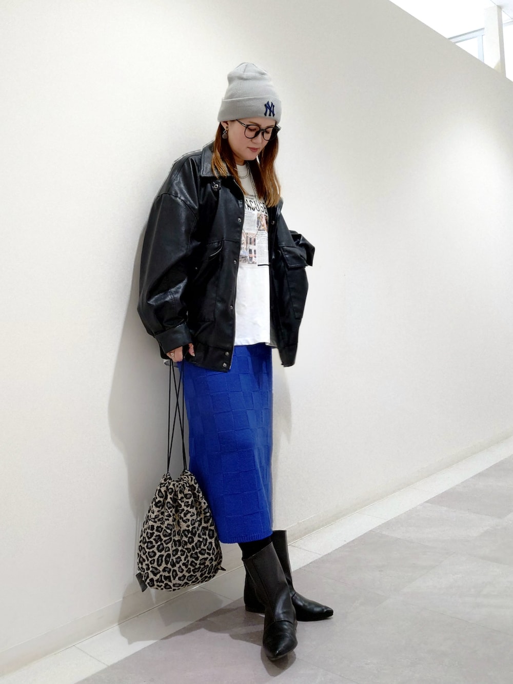 ブラック系のブルゾン、ブラック系のブーツ、ブルー系のスカートを着用したレディースの秋コーディネートの2枚目の写真