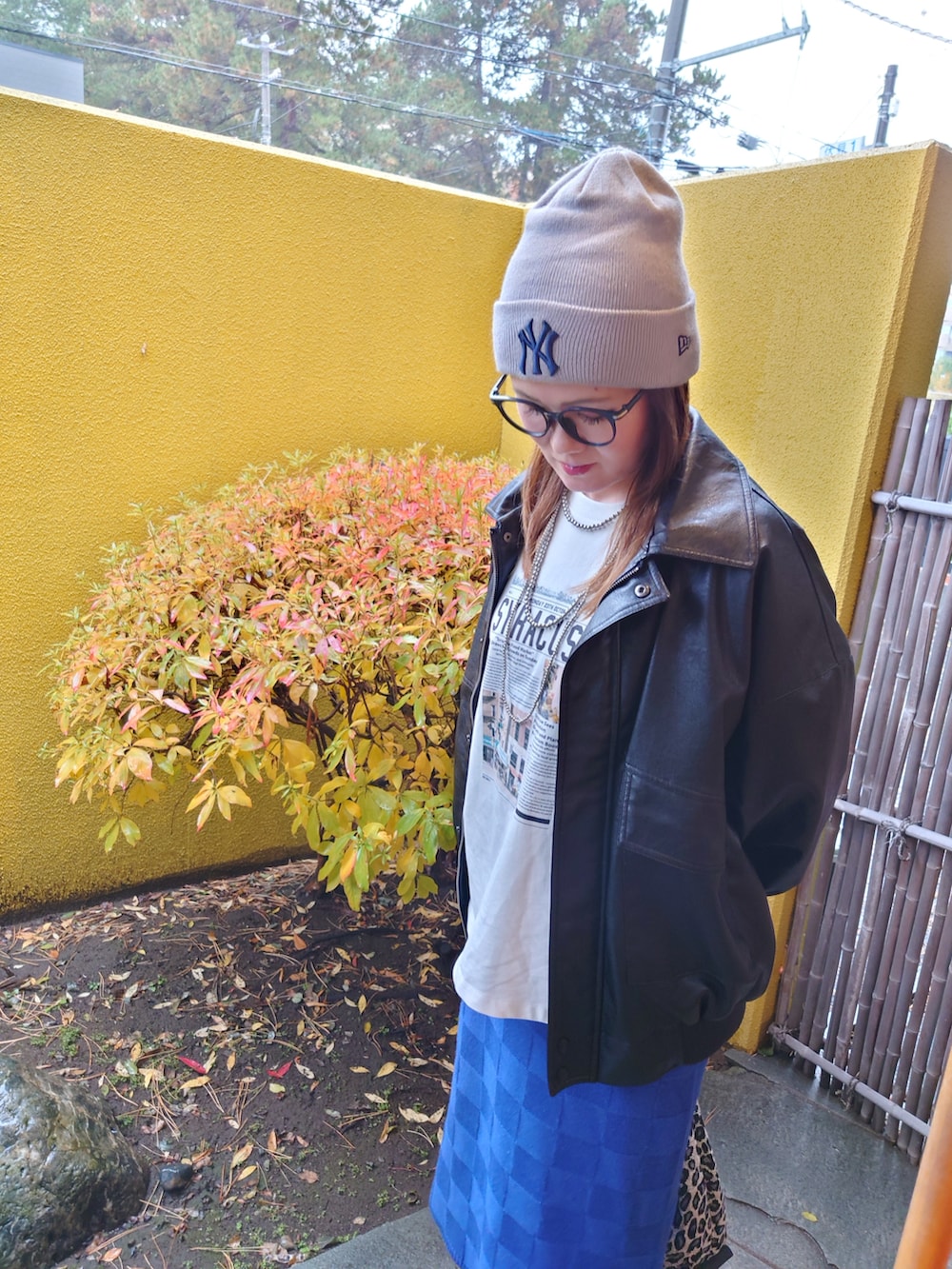 ブラック系のブルゾン、ブラック系のブーツ、ブルー系のスカートを着用したレディースの秋コーディネートの3枚目の写真