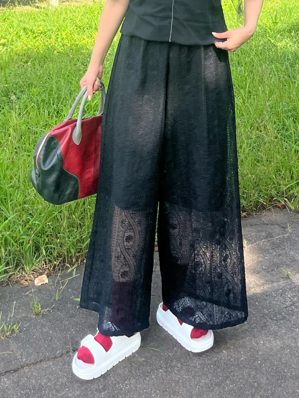 ブラック系のその他パンツ、ブラック系のTシャツ/カットソー、レッド系のトートバッグを着用したレディースの夏コーディネートの5枚目の写真