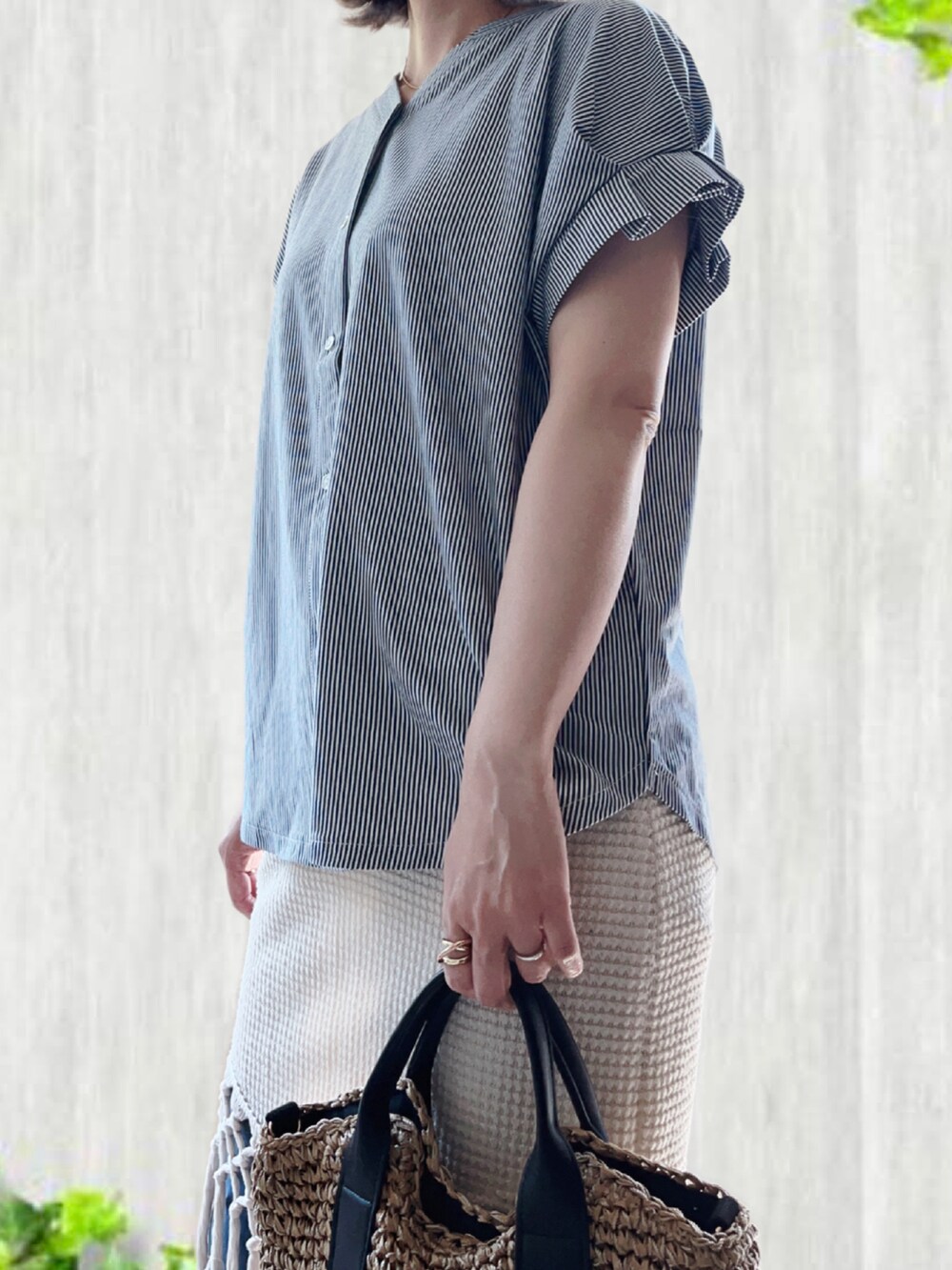 ブルー系のTシャツ/カットソー、ブラック系のショルダーバッグ、ベージュ系のスニーカーを着用したレディースの夏コーディネートの4枚目の写真