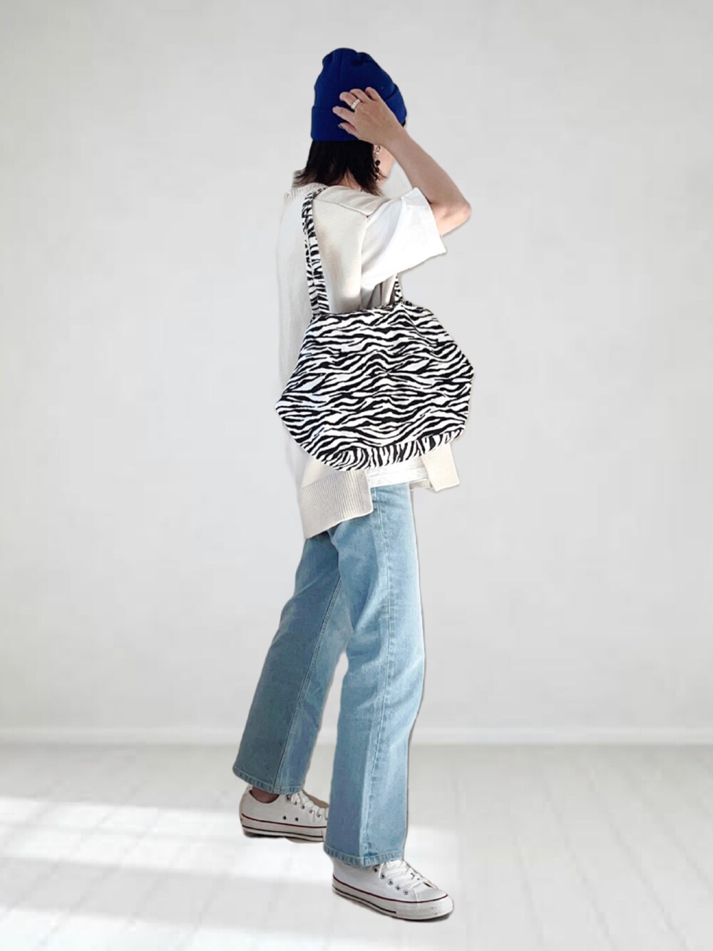 ブルー系のデニムパンツ、ホワイト系のベスト、ホワイト系のTシャツ/カットソーを着用したレディースの夏コーディネートの2枚目の写真